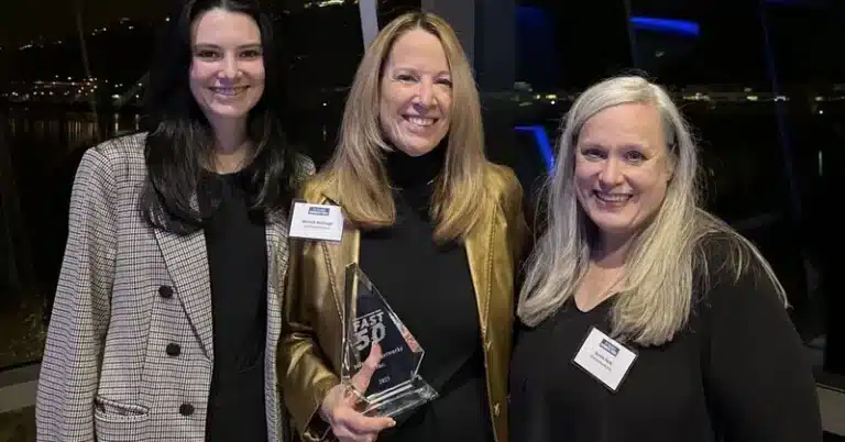 solutions4networks team members posing for a photo while holding the Fast 50 award