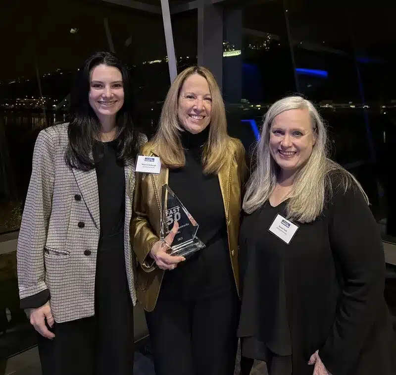 solutions4networks team members posing for a photo while holding the Fast 50 award